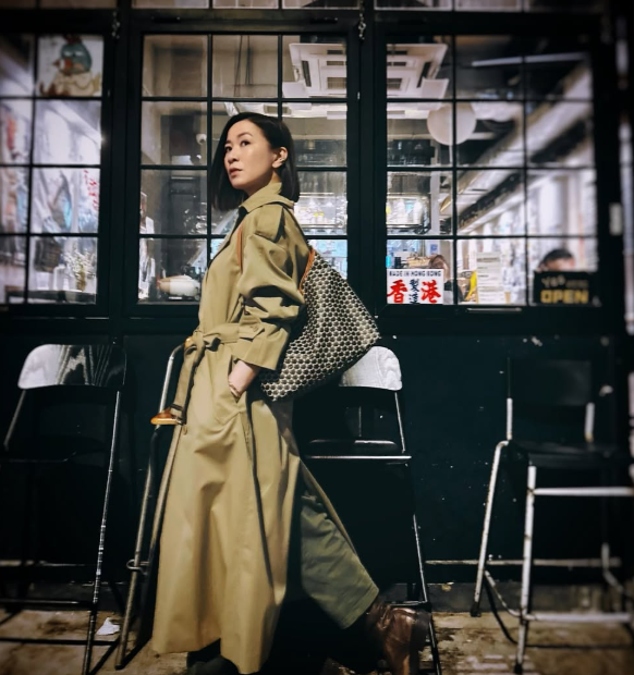 佘詩曼穿著卡其色風衣及大容量托特包，展示素顏凍齡膚質與簡約都市時尚風格。