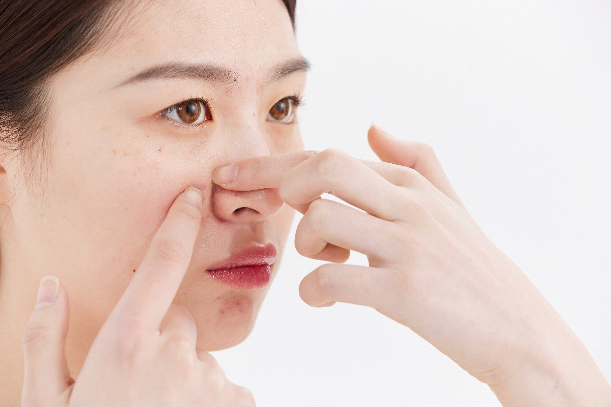 女生檢查鼻頭黑頭粉刺，用手擠痘痘，Beauty100 建議使用 GLOW² 微米毛孔槍進行醫學級深層清潔療程。